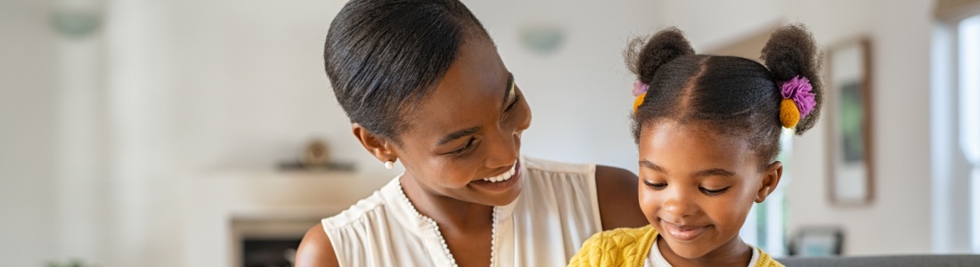 A woman with her child on her knee holding a piggy bank.