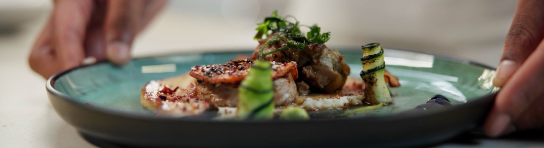 A chef prepares a dish in a fine dining restaurant.