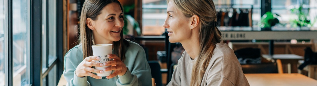 Two women talking in a coffee shop.