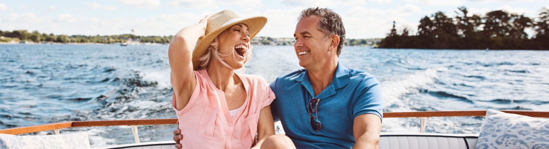 A couple in their 50s laughing on a boat together.