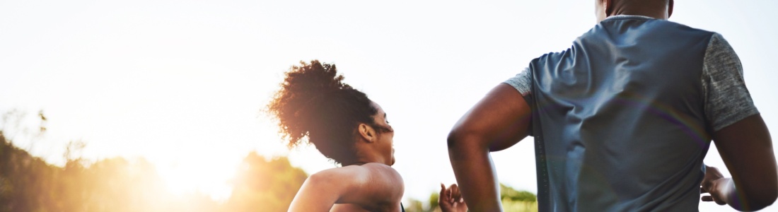A couple running through a park.