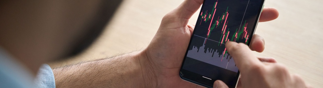 A man looking at investment performance on his phone.