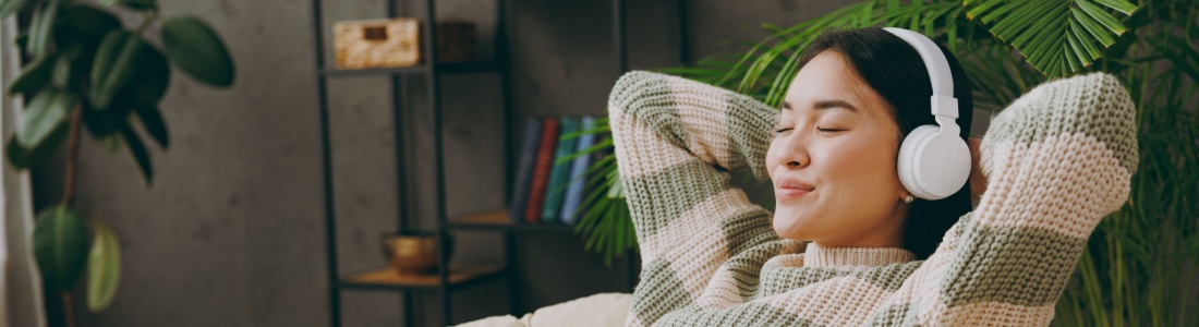 A woman relaxing with headphones on.