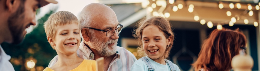 A grandfather laughing with his grandchildren.