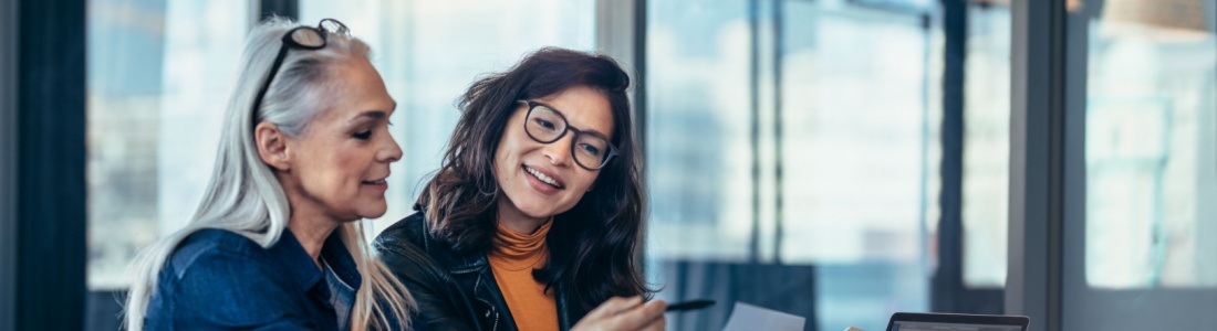 A woman talking to a colleague in an office.