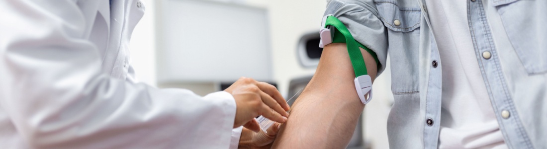 A doctor preparing to draw blood from a man.
