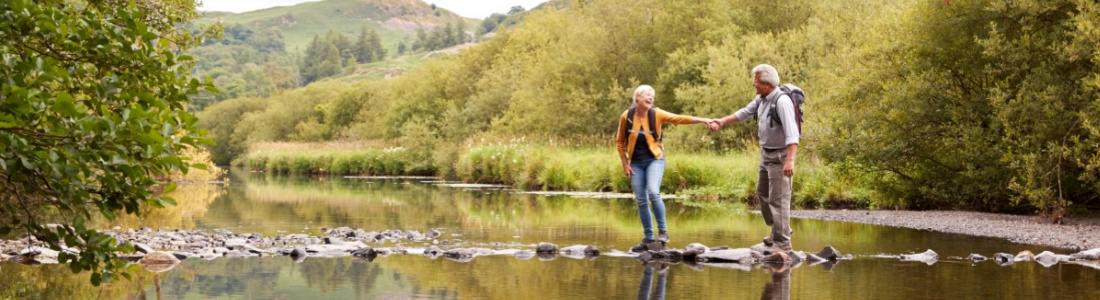 A couple walking across stepping stones.