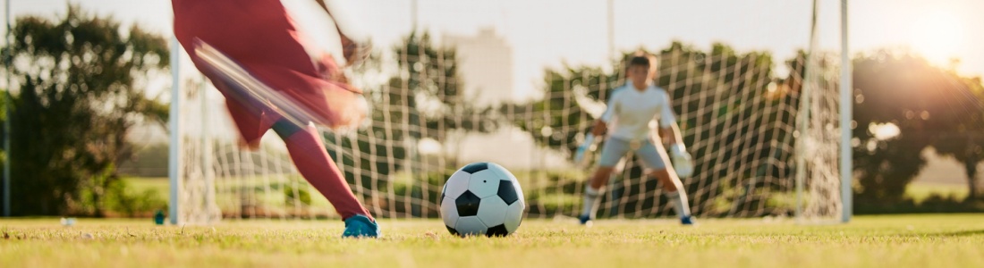 A footballer taking a shot at a goal.