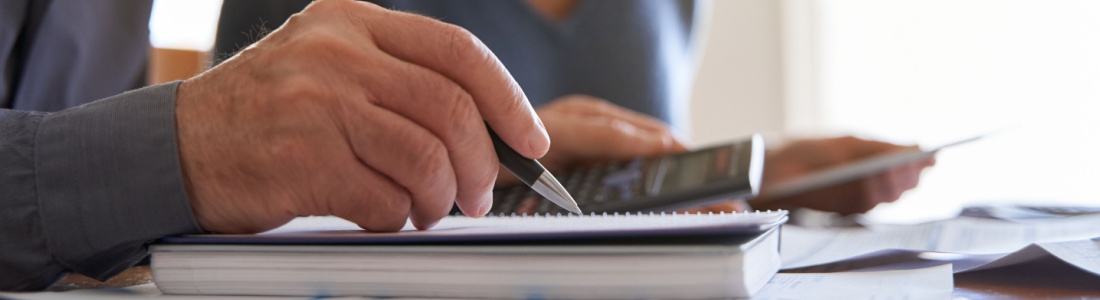 Couple looking at paperwork and using a calculator