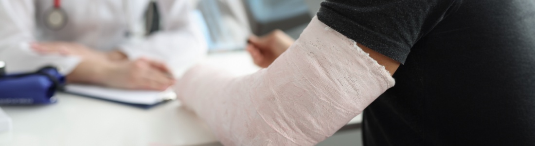 A man with a broken arm speaking with a doctor.