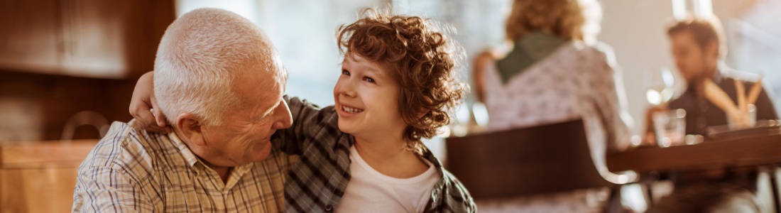 Grandfather hugging his grandchild.
