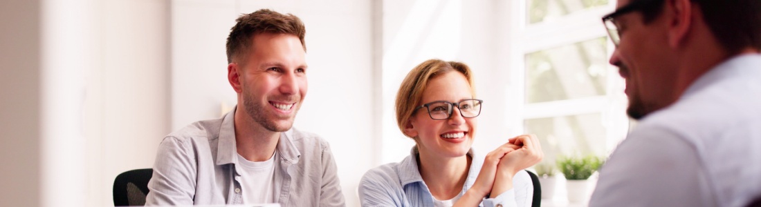 A couple happily talking with their financial planner.