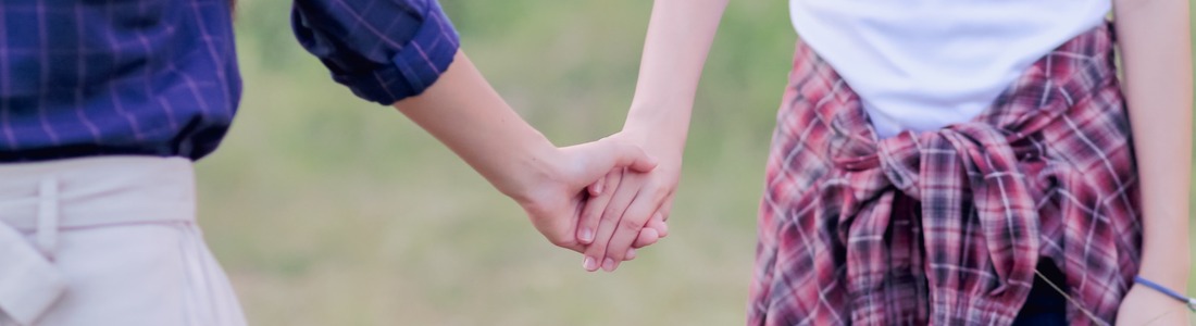 Two women holding hands.